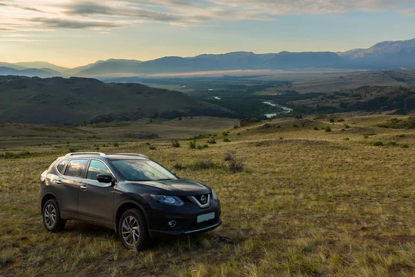Crossover Nissan X-Trail Kurai bozkır şafak Kuzey Chuy Ridge'te zemin karşı yamaca.