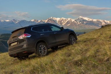 Crossover Nissan X-Trail Kurai bozkır şafak Kuzey Chuy Ridge'te zemin karşı yamaca.