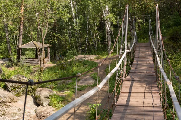 Wooden gazebo and suspension bridge across the Belokurikha mountain river on terrenkur health trail — Stock Photo, Image
