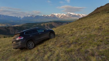 Crossover Nissan X-Trail Kurai bozkır şafak Kuzey Chuy Ridge'te zemin karşı yamaca.