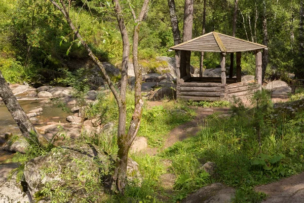 Wooden arbor on the bank of the mountain river Belokurikha on terrenkur health trail — Stock Photo, Image