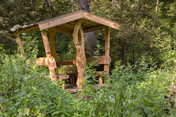 Schöne aus Holz geschnitzte Laube auf dem Terrenkur-Gesundheitspfad entlang des Belokurikha-Gebirgsflusses Stockbild