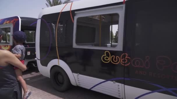 Bus for transporting tourists from the car park to the entrance to the Dubai Parks and Resorts stock footage video — Stock Video