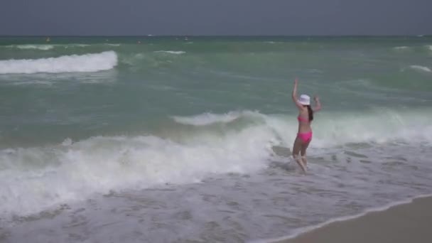 Tienermeisje in een badpak springt gelukkig in de golven van de Perzische Golf op strand Dubai stock footage video — Stockvideo