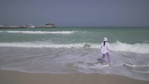 Ragazza adolescente con papà andare nelle onde del mare del Golfo Persico sulla spiaggia di Dubai stock footage video — Video Stock