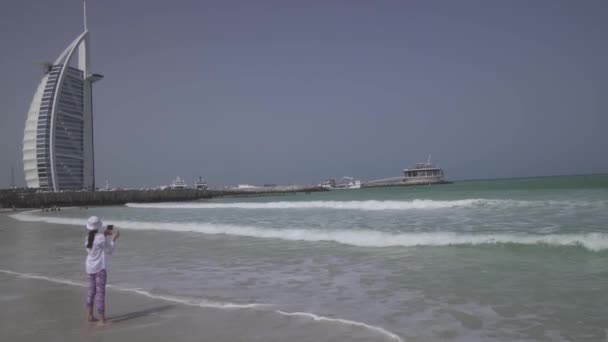Nastoletni Dziewczyna robi zdjęcia fal morskich na publiczne Jumeirah Beach Open na wybrzeżu Zatoki Perskiej, Dubai Stockowy wideo — Wideo stockowe