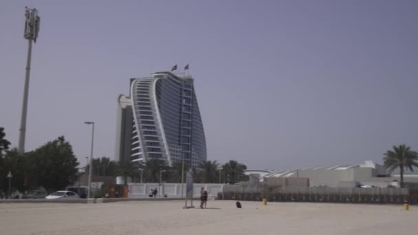 Jumeirah Beach Hotel y Burj Al Arab Hotel en Public Jumeirah Open Beach en la costa del Golfo Pérsico, Dubai — Vídeo de stock