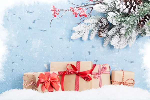 Gift boxes and snowy fir branch — Stock Photo, Image