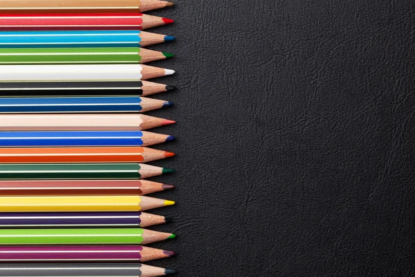 Coloured pencils on black leather — Stock Photo, Image