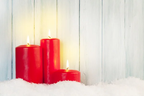 Κεριά στο χιόνι μπροστά από το ξύλινο τείχος — Φωτογραφία Αρχείου