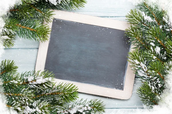 Chalkboard and fir tree with snow — Stockfoto