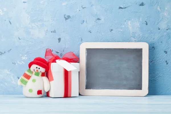 Świąteczny prezent z chalkboard i zabawka bałwana — Zdjęcie stockowe