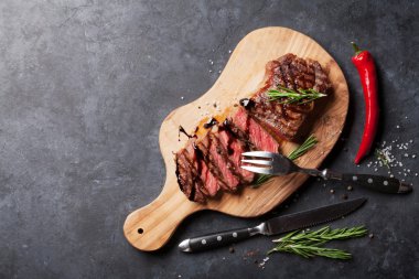 Kesme tahtası üzerinde ızgara striploin biftek