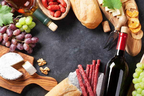 Flaschen mit Wein und Käse auf Schneidebrettern — Stockfoto