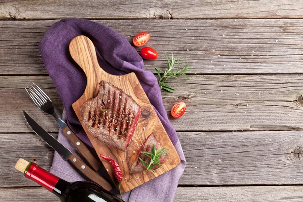 Gegrilde rundvlees steak en wijn fles — Stockfoto