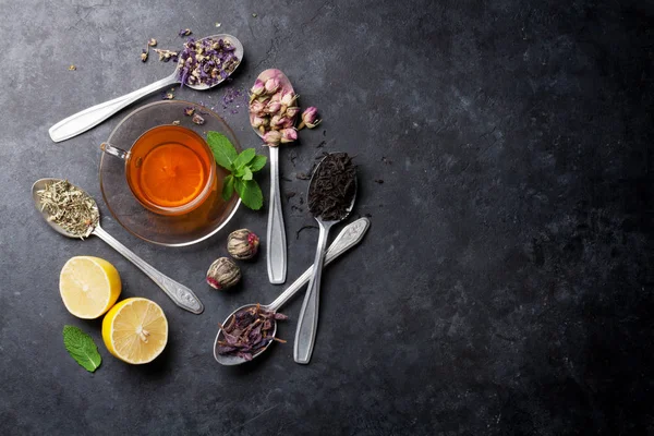 Tekopp och sortiment av te i skedar — Stockfoto
