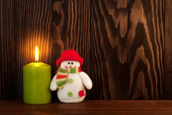 Vánoční svíčka a sněhulák hračka — Stock fotografie