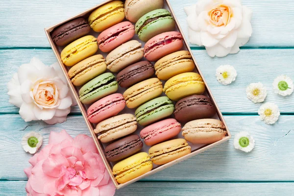 Macarrones coloridos en caja de regalo y rosas — Foto de Stock