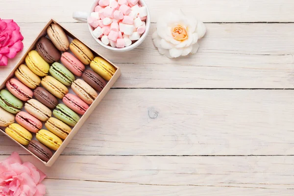 Macaroons coloridos em caixa e xícara com marshmallows — Fotografia de Stock