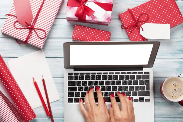 Kadın çalışma üstünde laptop hediye ambalajlama ve paketleme için — Stok fotoğraf