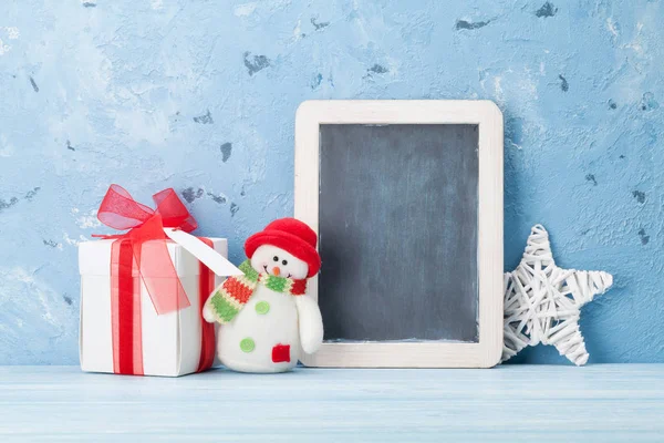 Christmas chalkboard, snowman and gift box — Stock Photo, Image