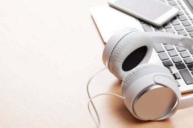 Kulaklık ve smartphone dizüstü bilgisayar üzerinde 