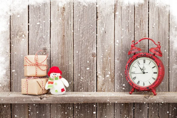 Christmas gift boxes, snowman and alarm clock — Stock Photo, Image