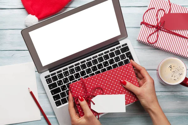 Frau arbeitet am Laptop und verpackt Geschenke — Stockfoto