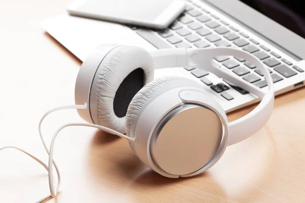 Headphones over laptop on table — Stock Photo, Image