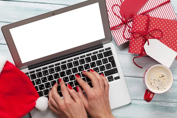 Frau arbeitet am Laptop und verpackt Geschenke — Stockfoto