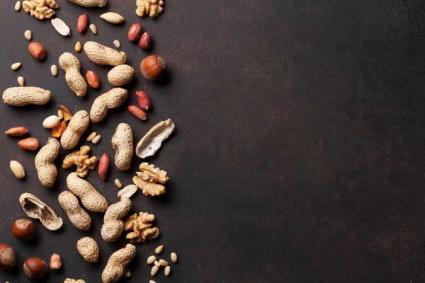Различные орехи на каменном столе — стоковое фото