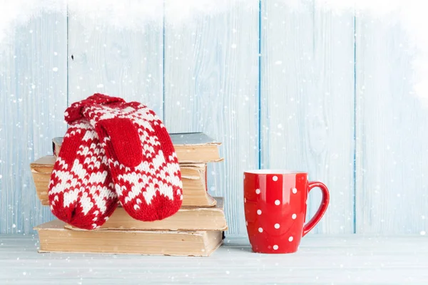 Hot chocolate and mittens over books — Stock Photo, Image