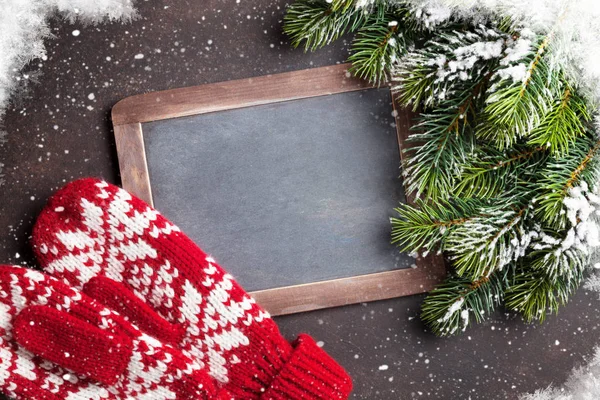 Christmas fir tree, mittens and chalkboard — Stock Photo, Image