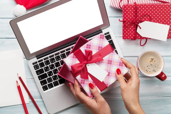 Female working on laptop and wrapping gifts — Stock Photo, Image