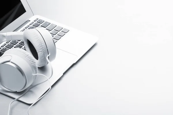 Headphones and laptop on wooden desk — Stock Photo, Image