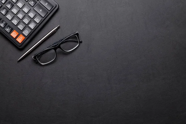 Schreibtisch mit Taschenrechner, Stift und Brille — Stockfoto