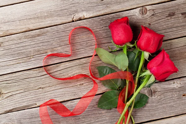 Rosas rojas y cinta en forma de corazón —  Fotos de Stock