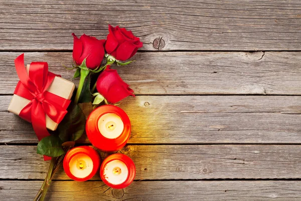 Rote Rosen, Kerzen und Geschenkkarton — Stockfoto