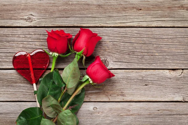 Rose rosse e cuore di caramelle — Foto Stock
