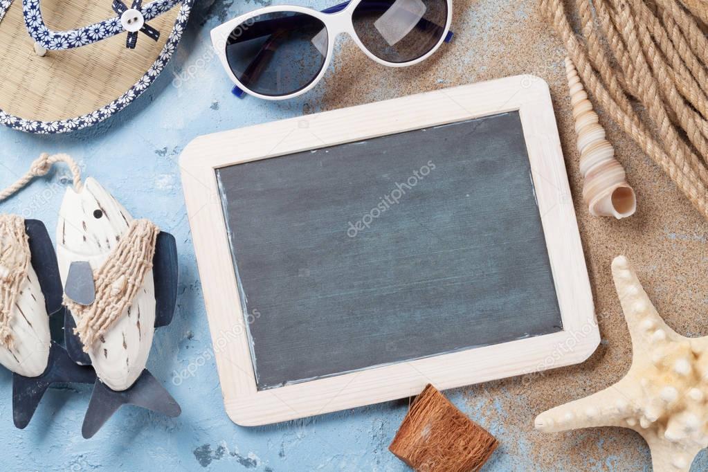 Flip-flops, sunglasses, seashells and blackboard
