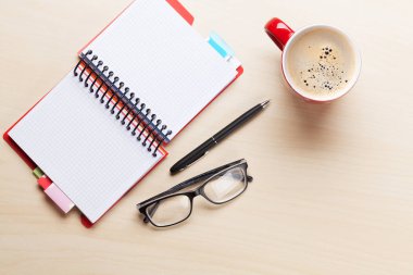 kahve fincanı, not defteri, kalem ve gözlük