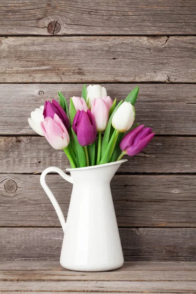 Букет з різнокольорових тюльпанів у глечику — стокове фото