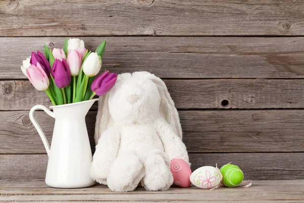 Rabbit toy, easter eggs and tulips — Stock Photo, Image