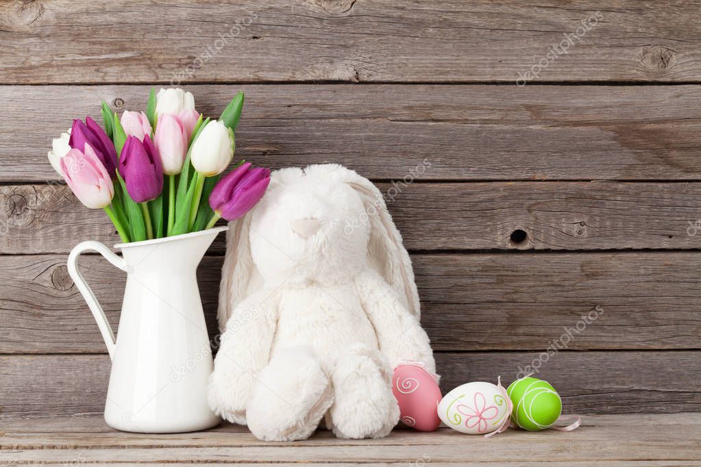 Rabbit toy, easter eggs and tulips