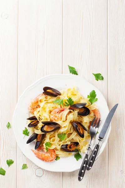 Pasta with seafood on wooden table — Stock Photo, Image