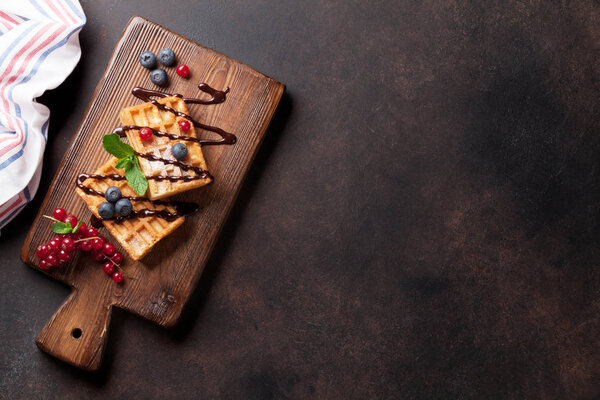 Waffles and berries on wooden board