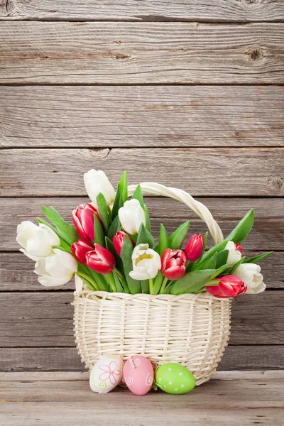 Tulipán csokor kosár és a húsvéti tojás — Stock Fotó