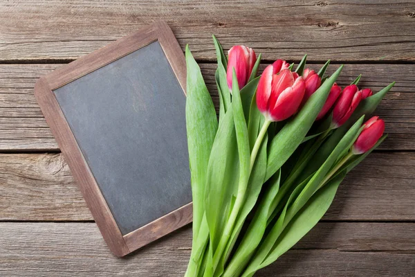 Red tulips bouquet and chalkboard — Stock Photo, Image