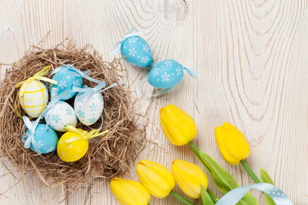 Ostern mit Eiern und gelben Tulpen — Stockfoto