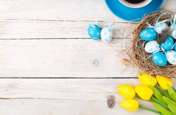 Eggs in nest, yellow tulips and coffee — Stock Photo, Image